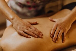 Accueil Close-up of hands giving a soothing back massage in a calm setting.